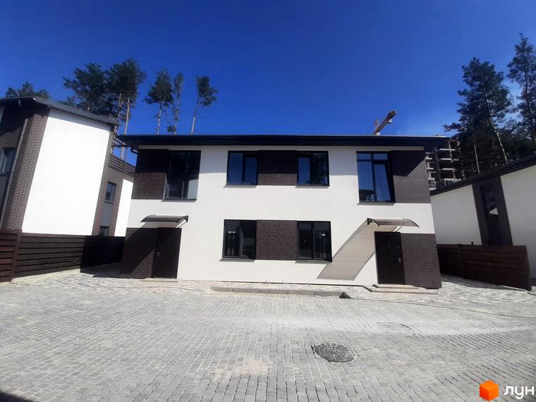 Котеджне містечко КМ Лісове-3. Сучасні двоповерхові будинки з білою та темно-коричневою обробкою, великими вікнами та темними дверима. Прибудинкова територія вимощена бруківкою.