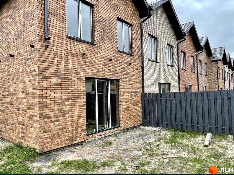 Таунхауси „Чемпіон“ з цегляним фасадом та прибудинковою територією з парканом. Зовнішній вигляд будинків та прибудинкової території.