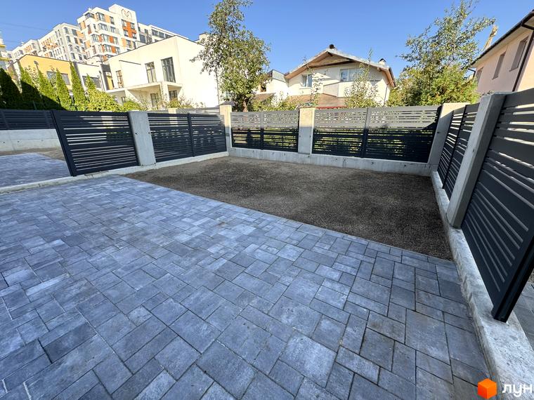 Зовнішній вигляд таунхаусів Loft House з сірим парканом та бруківкою на прибудинковій території. Фото новобудови.