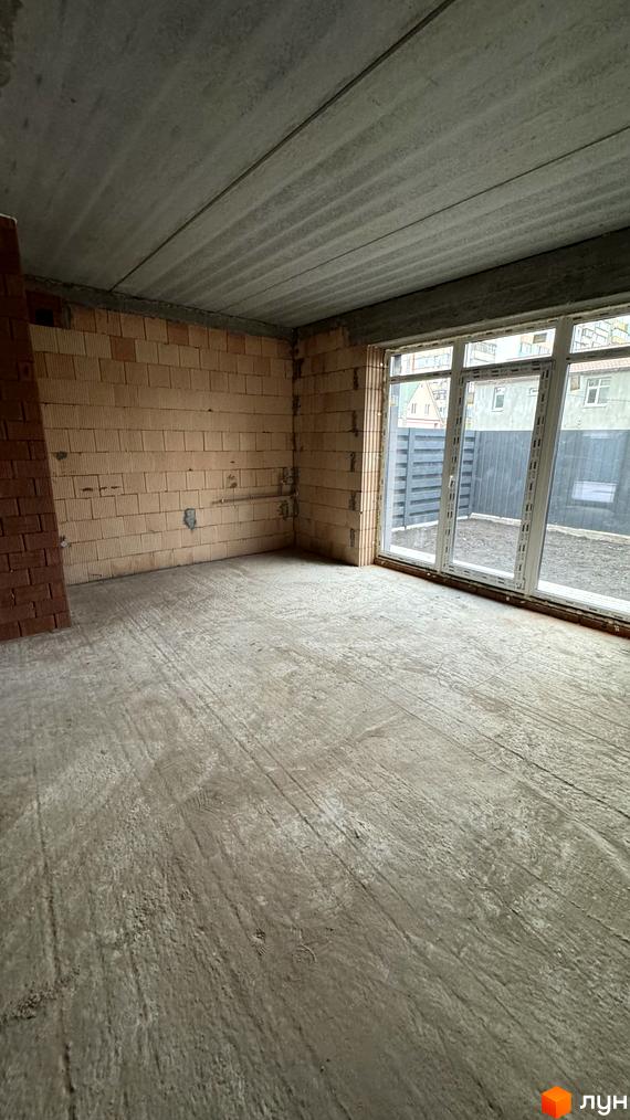 Таунхауси А56 – це новий житловий комплекс з цегляними стінами та великими вікнами, що виходять на огороджену прибудинкову територію.