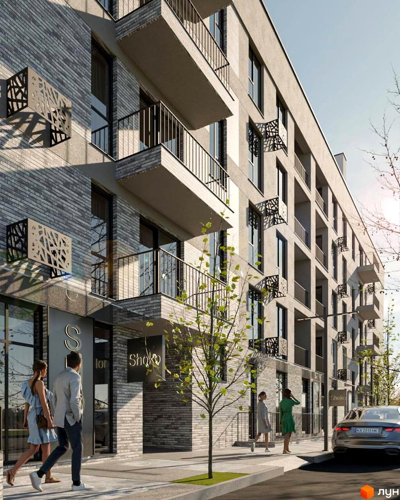 Зовнішній вигляд будинку житлового комплексу з балконами та декоративними елементами на фасаді. На тротуарі біля будинку стоять люди.