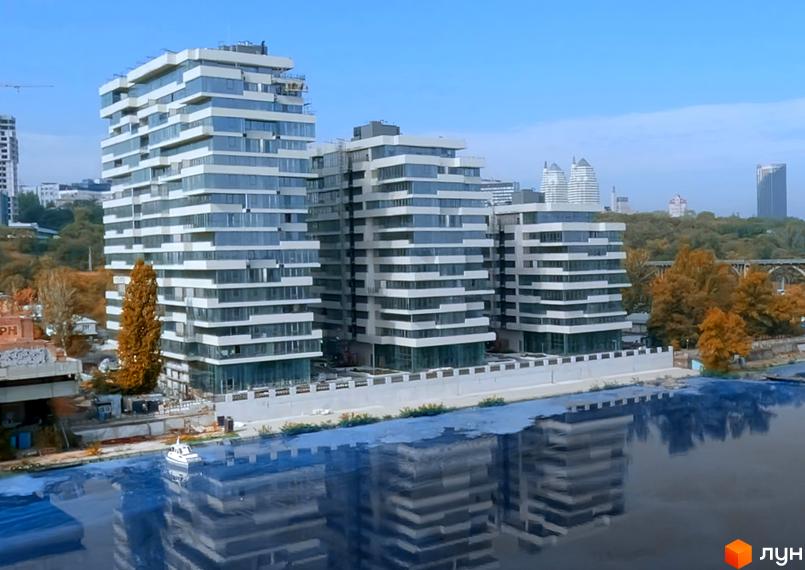 Апарт-комплекс Port City з фасадами з панорамних вікон та білих горизонтальних панелей, розташований біля річки.