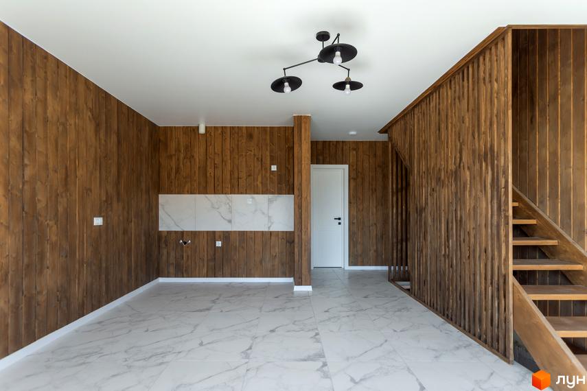 Інтер'єр будинку в КМ Схили з дерев'яними стінами та сходами на другий поверх. Сучасне оздоблення підлоги та стелі.