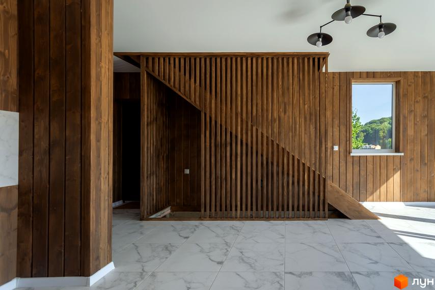 Дизайн інтер'єру житлового комплексу КМ Схили з дерев'яними елементами та великим вікном. Сучасний інтер'єр з натуральних матеріалів.