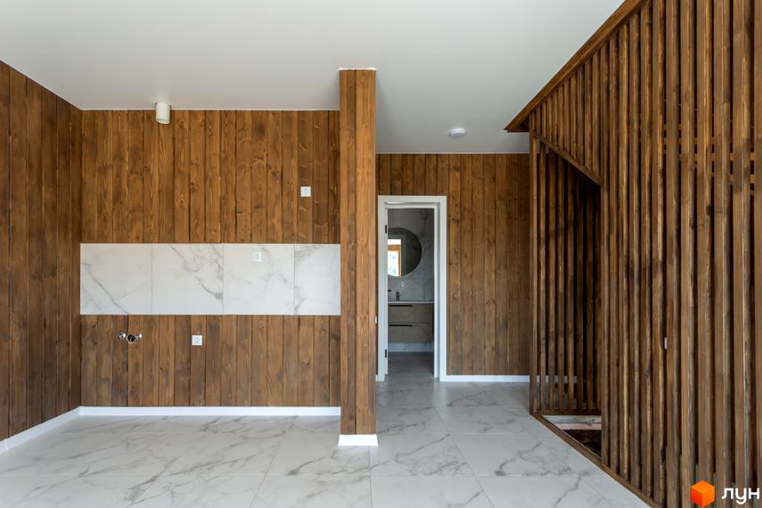 Інтер'єр квартири у Котеджному містечку Схили з дерев'яними стінами та мармуровою плиткою на підлозі. Відкритий простір з дверима до ванної кімнати.