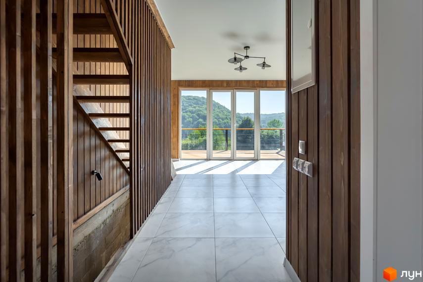 Котеджне містечко Схили: дерев'яні сходи та панорамні вікна з видом на зелені схили. Просторий хол з мармуровою підлогою та сучасним освітленням.