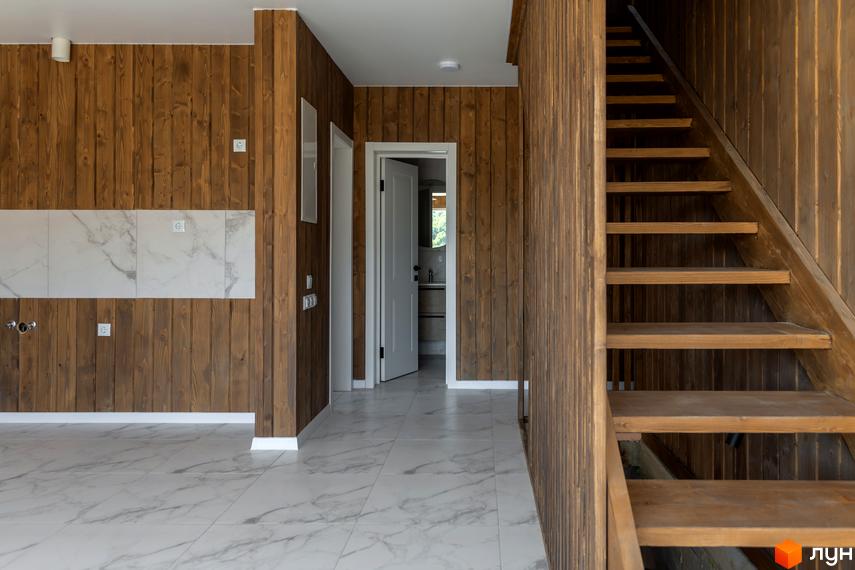 Інтер'єр будинку в котеджному містечку КМ Схили з дерев'яними стінами та сходами, білою плиткою на підлозі та стінах.