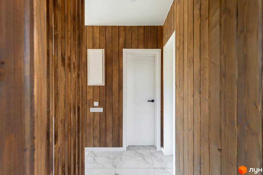 Котеджний комплекс КМ Схили. Інтер'єр будинку з дерев'яними стінами та білими дверима.