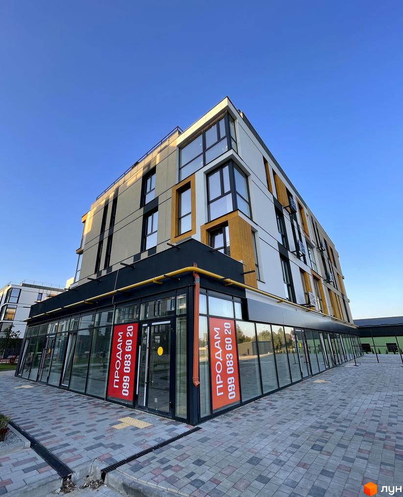 Зовнішній вигляд будинку в Житловому комплексі U HOME. Фасад будівлі та прибудинкова територія з тротуарною плиткою.