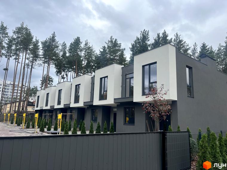 Сучасні таунхауси з білими фасадами та темними вікнами на вулиці Козацькій, 5. Поруч зелені насадження та паркан.