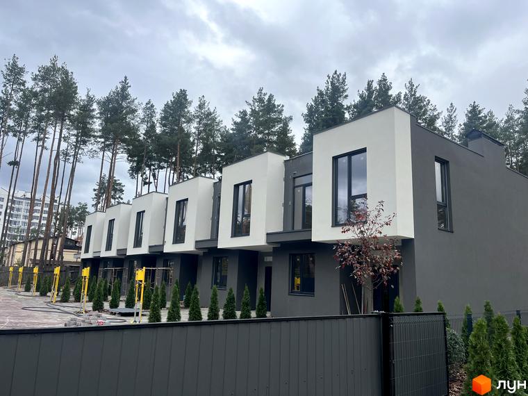 Ряд двоповерхових таунхаусів з темно-сірим низом та білим верхом на вул. Козацькій. Перед будинками висаджені вічнозелені кущі та є вимощена територія.