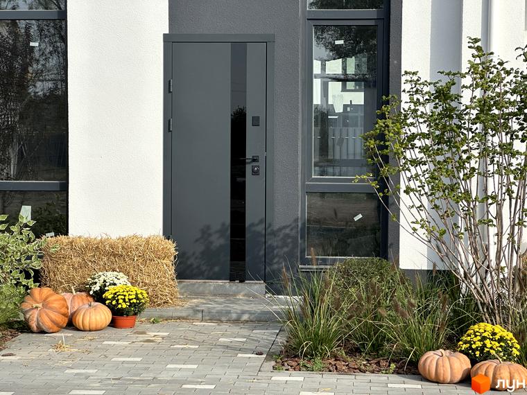 Котеджне містечко KМ Gardd House Eco Village. Зовнішній вигляд будинку та прибудинкова територія з осіннім декором у вигляді гарбузів та квітів.