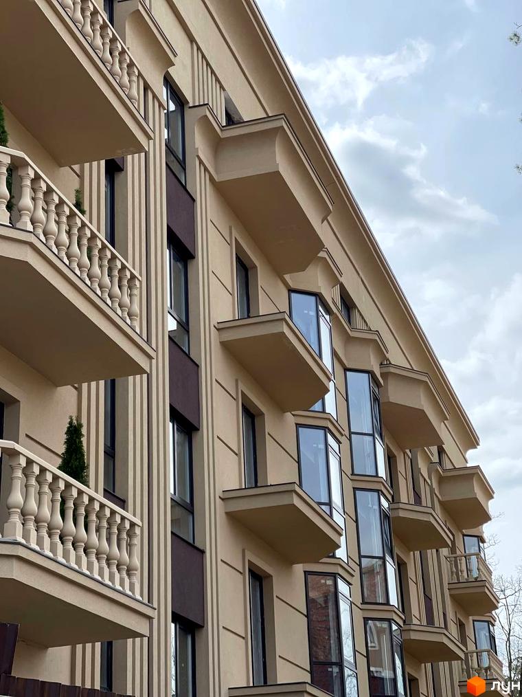 Фасад житлового комплексу Monaco з балконами та вікнами. Зовнішній вигляд будівлі з бежевим оздобленням та колонами.