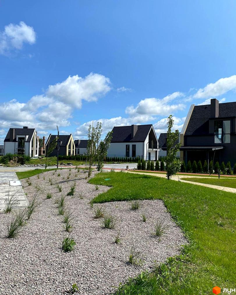 Котеджне містечко BELLAGIO: сучасні будинки з темними дахами та білими фасадами, охайний ландшафт з газонами та кам'яною відсипкою.