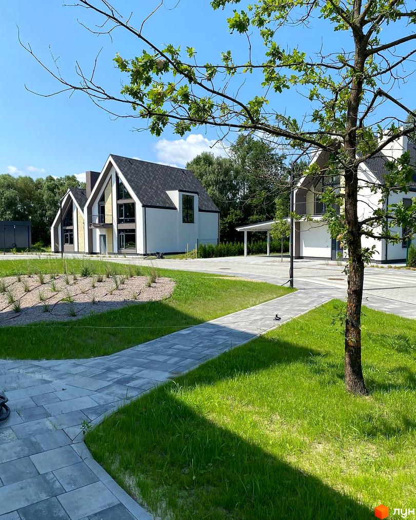 Котеджне містечко BELLAGGO: білі будинки з темними дахами та великими вікнами, доглянута зелена територія з доріжками.