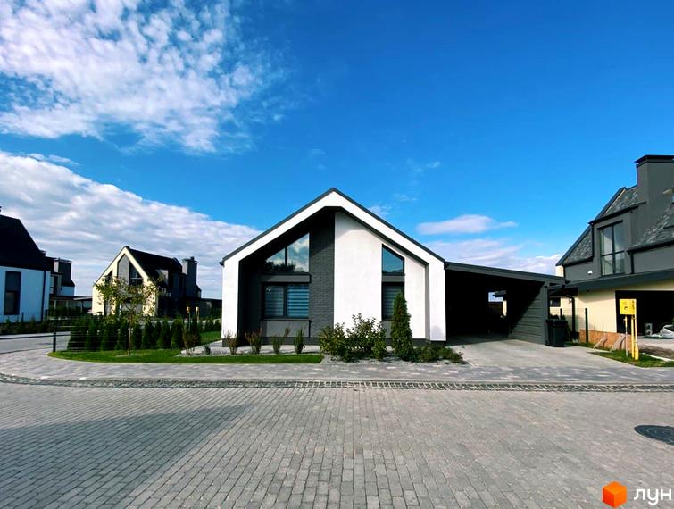 Котеджне містечко КМ VILLAGGO. Сучасні будинки з панорамними вікнами та доглянутою прибудинковою територією під блакитним небом.