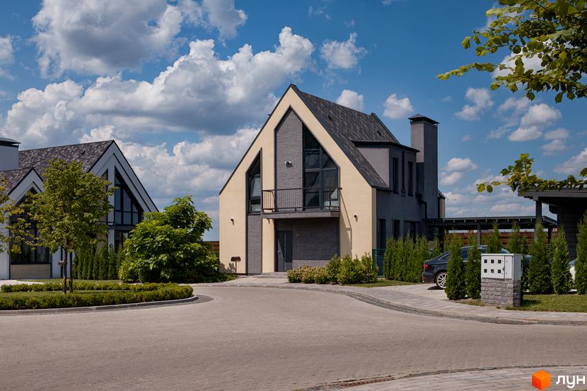 Котеджне містечко KM VILLAGGO. Сучасні будинки з великими вікнами та сірими дахами розташовані на доглянутій території з бруківкою та зеленими насадженнями.