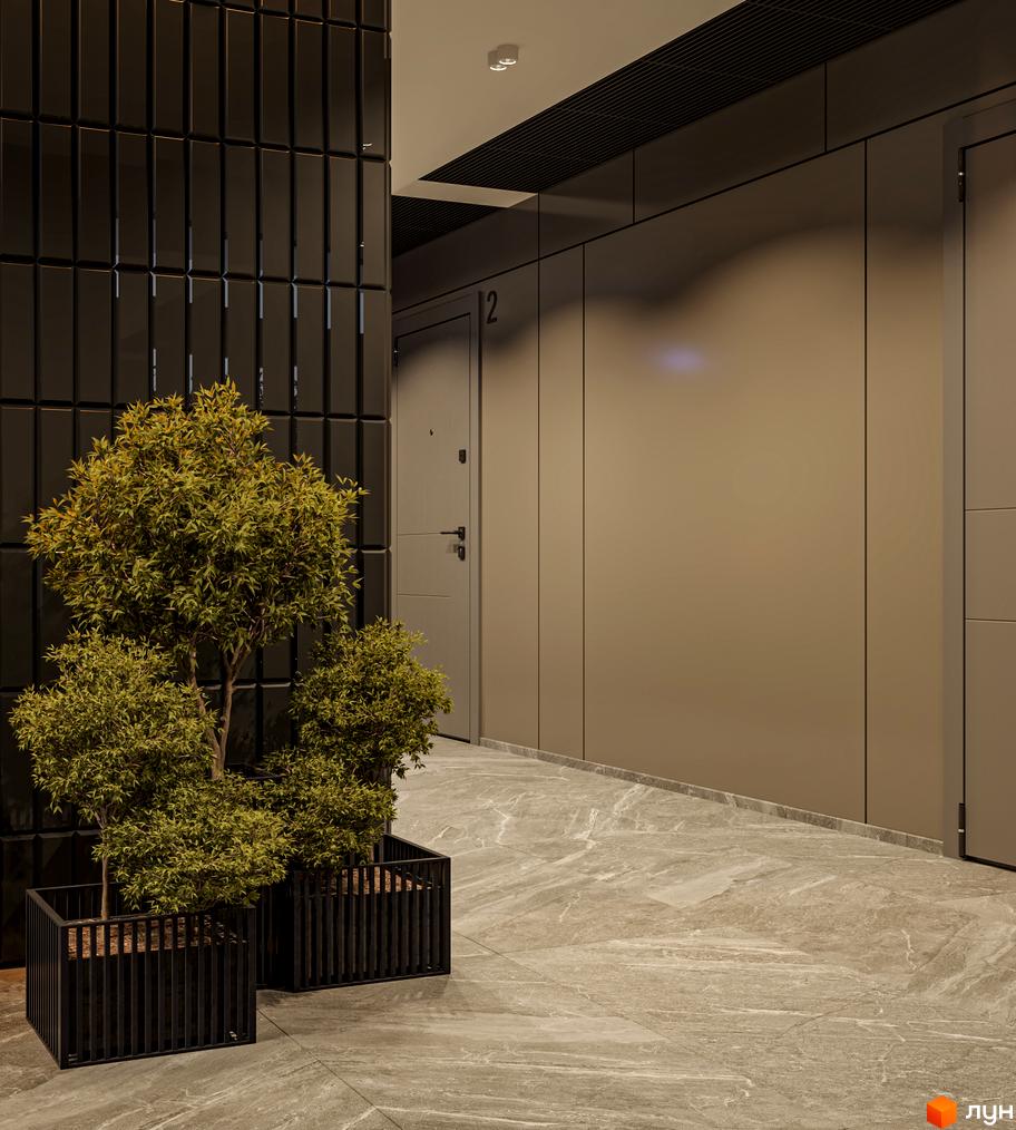 Інтер'єр вхідної зони Житлового комплексу на вулиці Лікарська, 12. Дерева у чорних вазонах біля стіни з темної плитки.