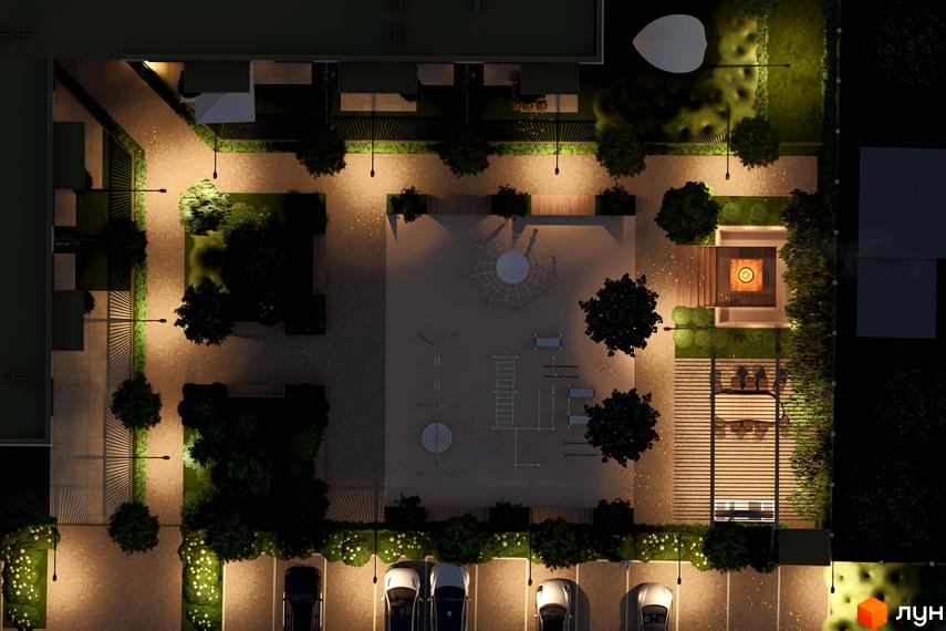 Нічний вид на житловий комплекс Минай з освітленим двором, дитячим майданчиком та паркінгом.