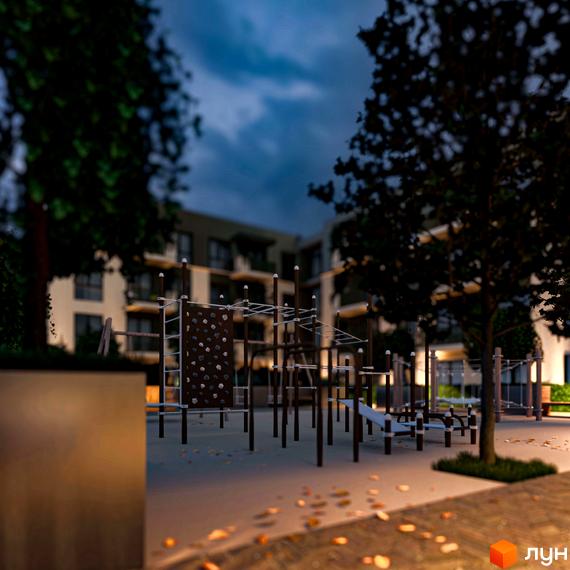 Новобудова Минай ввечері, з освітленим дитячим майданчиком та деревами на прибудинковій території.