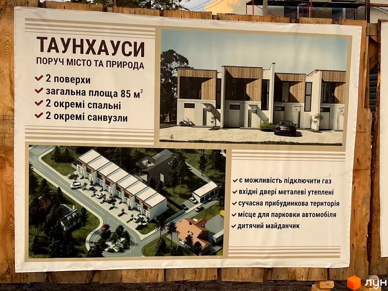Зображення таунхаусів поруч з містом та природою. На фотографії будинки з прибудинковою територією та місцем для парковки автомобілів.