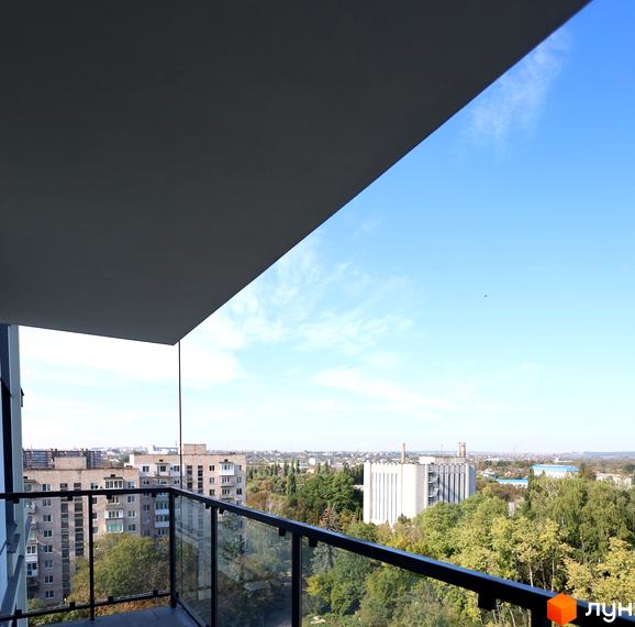 Вид з балкона на ЖК СОУРЕНЖ. Сучасна архітектура, скляні огорожі та зелені насадження.