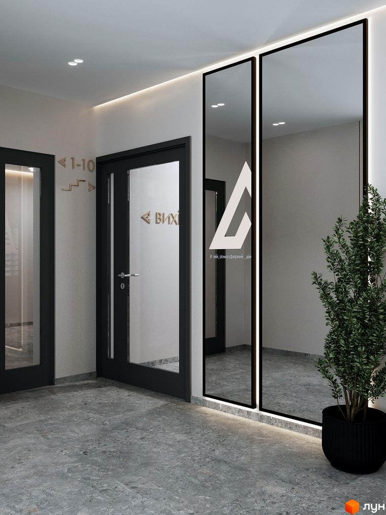 Сучасний вхід в житловий комплекс ATMOSFERA з дзеркалами та рослиною в горщику. Оздоблення стін та підлоги виконано в сірих тонах.