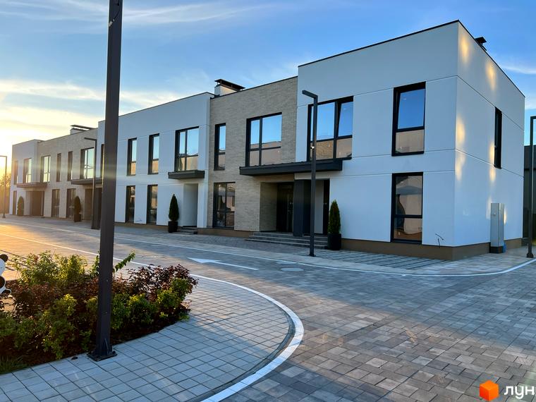 Таунхауси Soul City – сучасні двоповерхові будинки з великими вікнами та цегляними фасадами. Прибудинкова територія з бруківкою та зеленими насадженнями.