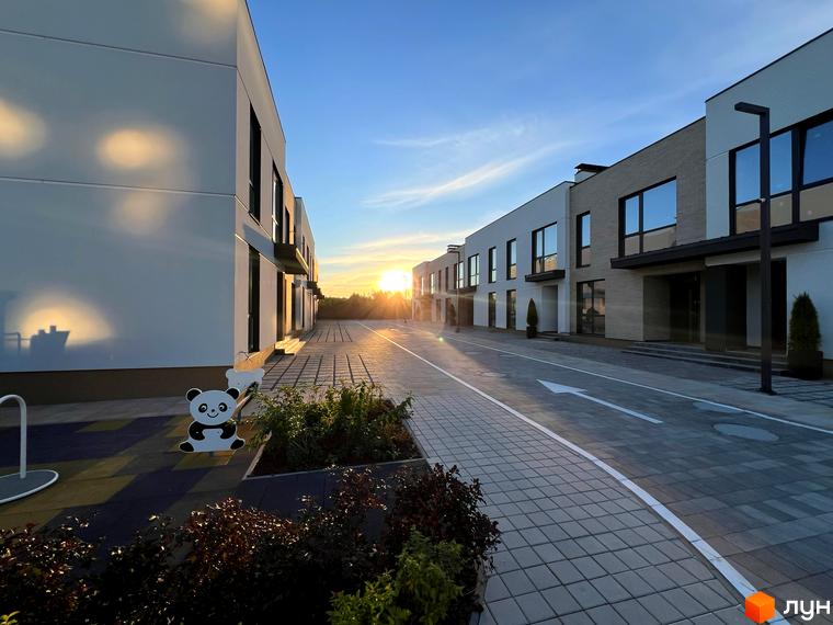 Таунхауси Soul City з фасадами світлих відтінків та великими вікнами. На території є вимощена дорога, зелені насадження та дитячий майданчик з пандою.