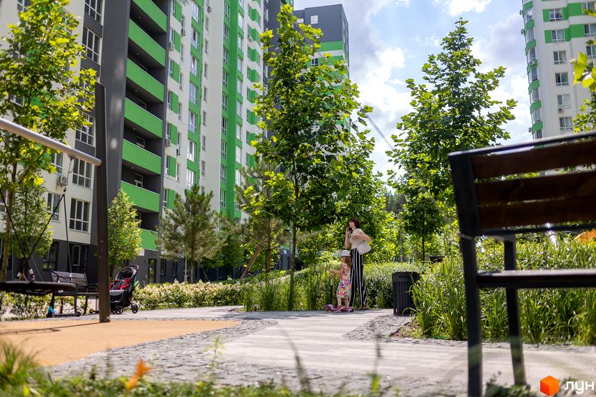 Житловий комплекс City Park з яскравими зеленими фасадами та доглянутою прибудинковою територією. На фото видно дитячий майданчик та зелені насадження.