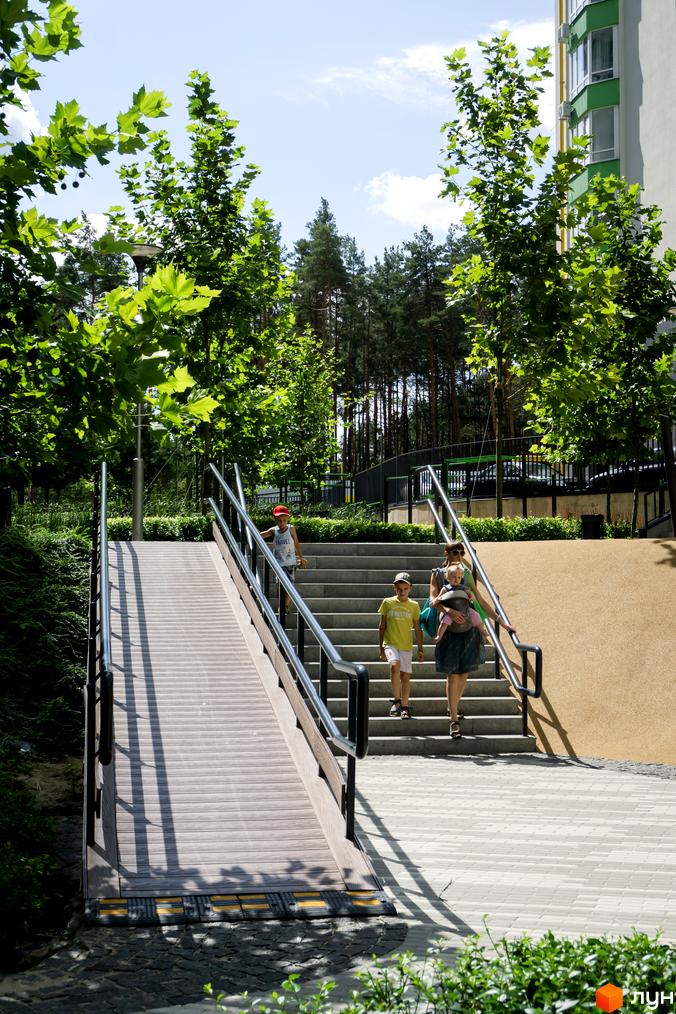 Новобудова ЖК City Park з зеленими елементами фасаду та прибудинковою територією зі сходами та пандусом. Фотографія житлового комплексу.