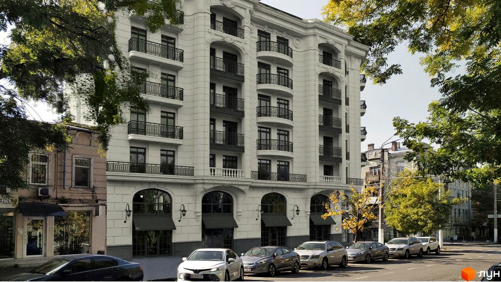 Багатоповерховий будинок Житлового комплексу Гімназист світлого кольору з темними вікнами та кованими балконами. Перед будинком припарковані автомобілі, обабіч ростуть дерева.