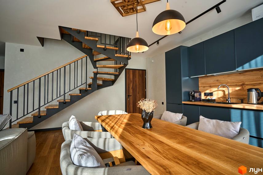 Інтер'єр FOMICH RESIDENCE GUESTHOUSES з дерев'яним столом, кухнею та сходами. Сучасний дизайн житлового комплексу.