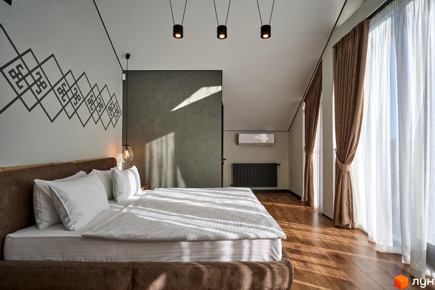 Інтер'єр кімнати в FOMICH RESIDENCE GUESTHOUSES: велике ліжко з білою постіллю, дерев'яна підлога та штори на вікнах.