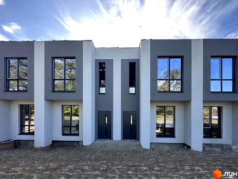 Зовнішній вигляд таунхаусів FLAGMAN RESIDENCE. Фасад будинку в сірих та білих тонах, великі вікна з відображенням неба.