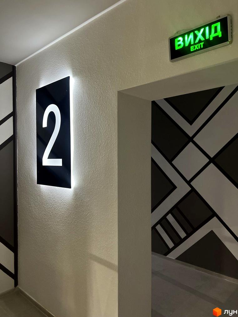 Житловий комплекс Буковинська 20А. Зовнішній вигляд новобудови з підсвіченим номером поверху та знаком 