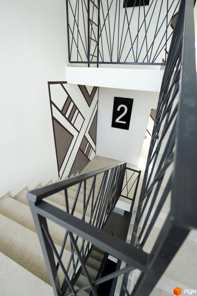 Буковинська 20А: сучасні сходи з металевими поручнями та декоративною стіною з геометричним візерунком. Номер поверху 