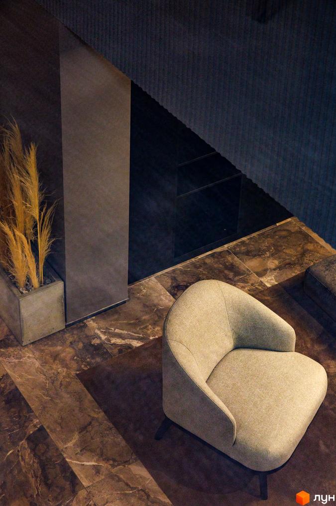 Дизайн інтер'єру вітальні в ЖК Avalon Prime з кріслом та декоративними рослинами. Сучасна обробка стін та підлоги.