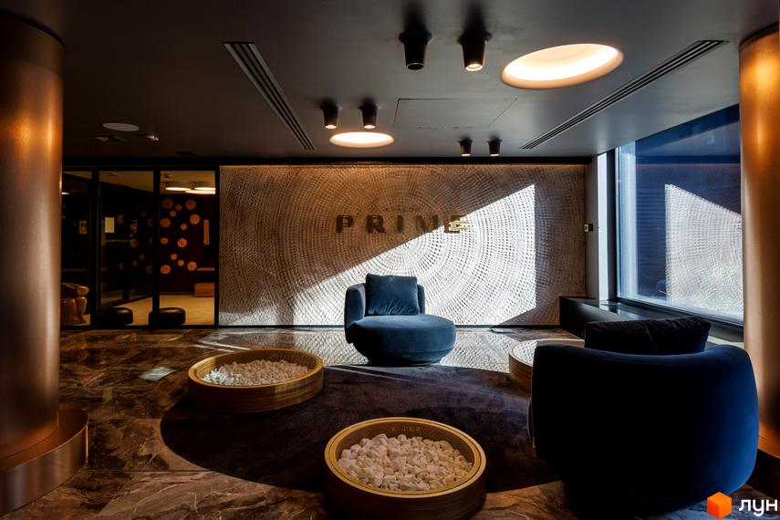 Інтер'єр лобі житлового комплексу Avalon Prime з диваном та декоративними елементами. Сучасний дизайн простору для відпочинку та очікування.