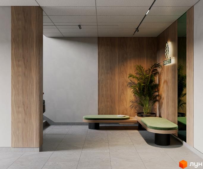 Інтер'єр холу в ЖК Зелений з лаконічними дерев'яними панелями, м'якими диванами та великою рослиною, що створює відчуття затишку та комфорту.