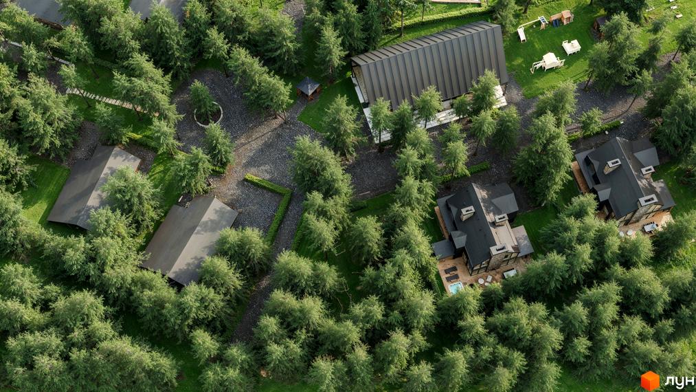 Вигляд зверху на котеджі з темними дахами, розташовані серед зелених дерев. Навколо будинків облаштована прибудинкова територія.