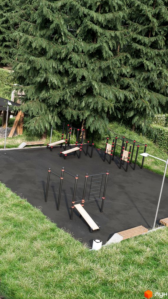 Облаштований спортивний майданчик для мешканців Guta Nova, з тренажерами та зонами відпочинку серед дерев.