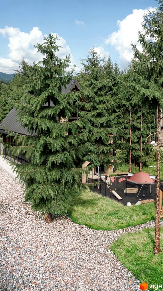 Вигляд згори на будинок з темним дахом в оточенні зелених дерев. На території є дитячий майданчик з гірками та гойдалками.