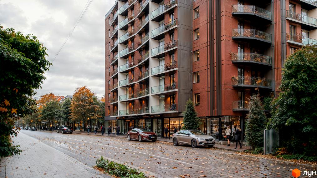 Житловий комплекс Рубін Апартамент - це цегляна багатоповерхова новобудова з балконами та вікнами. Перед будинком розташована вулиця з деревами та припаркованими автомобілями.