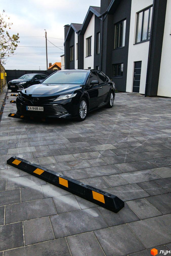 Зображення будинку по вулиці Шалімова, 36. На передньому плані припаркований автомобіль, а за ним ще один.