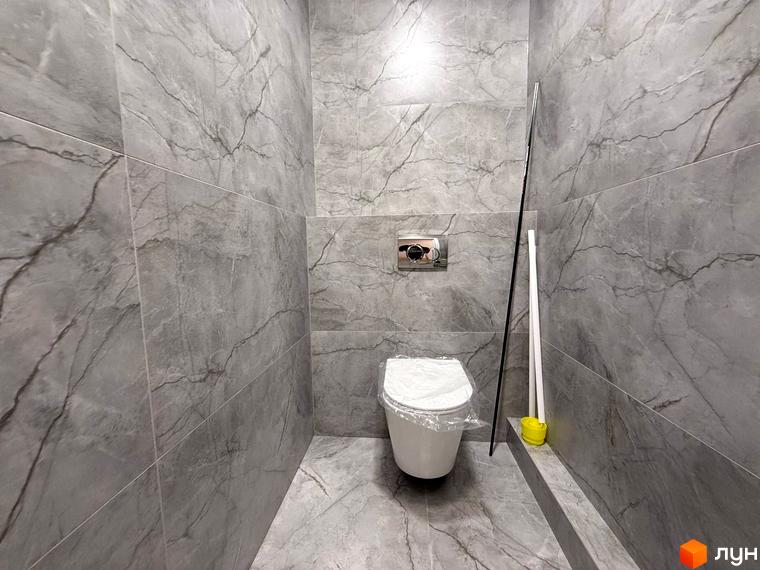 Ванна кімната в ЖК Comfort City з сірою плиткою під мармур та підвісним унітазом. Опис інтер'єру та дизайну новобудови.