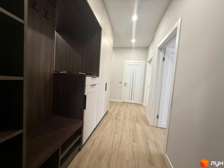 Передпокій у новобудові ЖК Comfort City з вбудованими шафами та лавкою. Сучасний дизайн та функціональне планування.