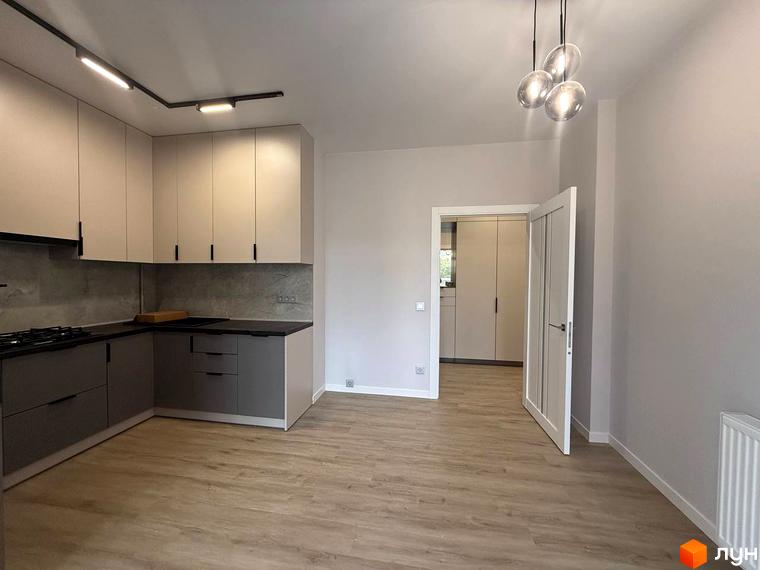 Сучасна кухня з сірими та бежевими фасадами в новобудові ЖК Comfort City. Простір об'єднаний з вітальнею, що створює відчуття простору.