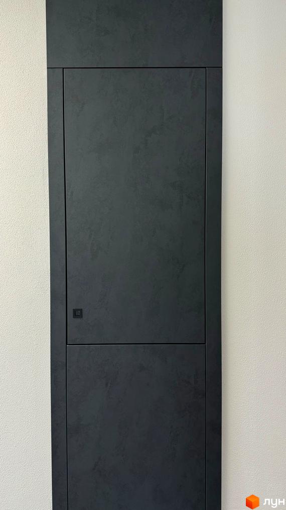 Темні двері з мінімалістичною ручкою на тлі світлої стіни. Зовнішній вигляд будинку ЖК GREENHOUSE CITY.