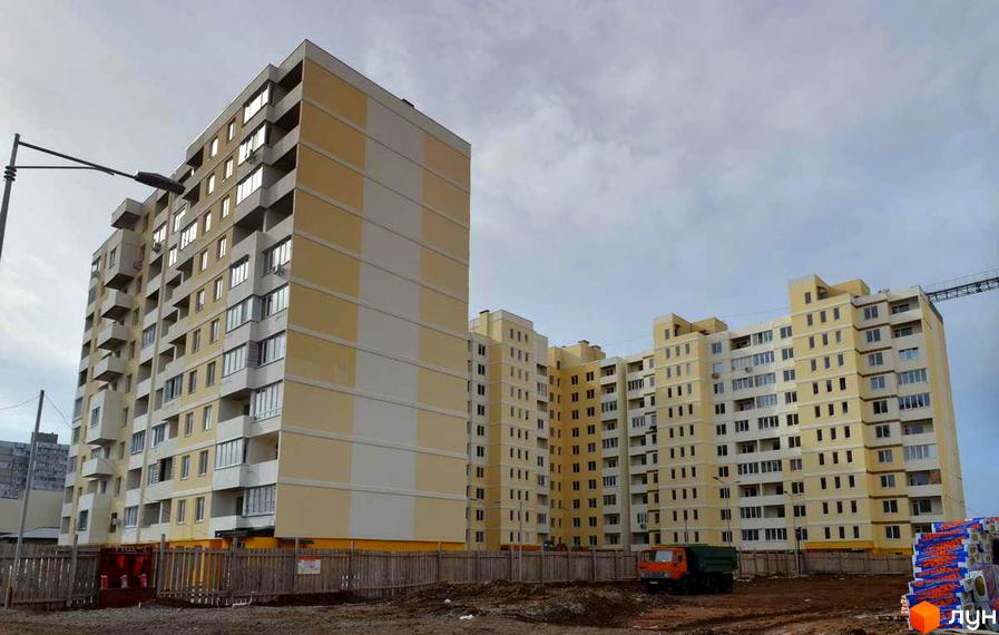 Житловий комплекс Суворівський 2. Багатоповерхові будинки з жовтими та білими фасадами. На території є огорожа та будівельна техніка.